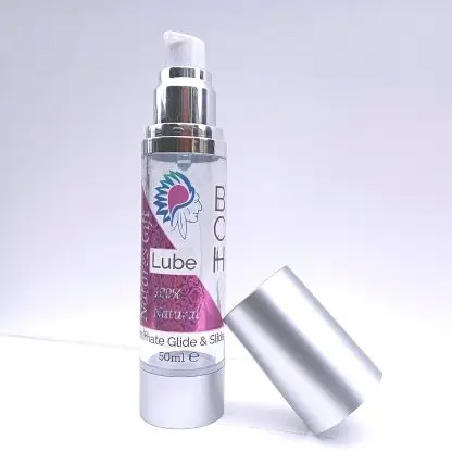 BCH Naturals coconut intimate oil in a glass pump bottle, placed on a bedside table for a discreet, calming nighttime ritual