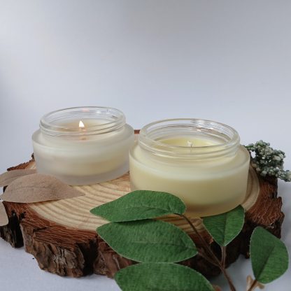 two orange candles on a slice of wood