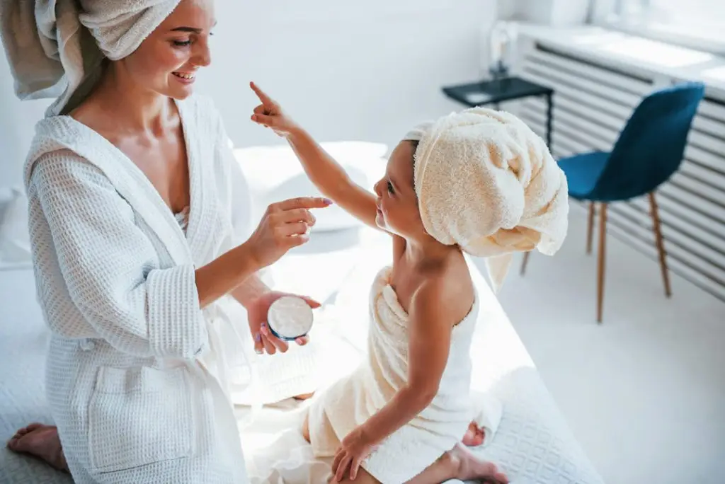 Mother and daughter in spa robes and towels enjoying a bonding moment during a skincare ritual — natural, nurturing wellness scene ideal for BCH Naturals’ home spa theme.