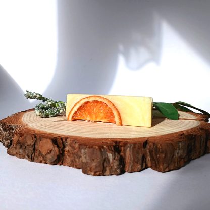 Orange Soap Bar on top of a slice of wood