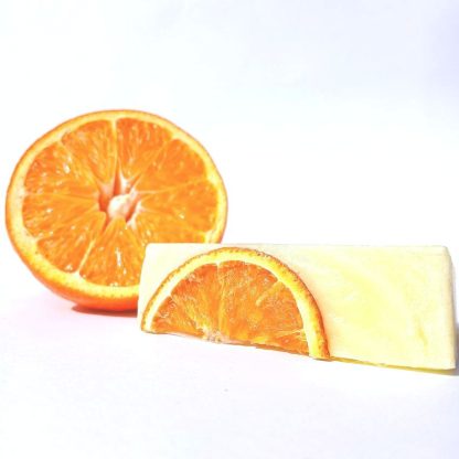 Close-up of Orange Serene artisan soap bar showing smooth texture and citrus detailing, enriched with half a real orange
