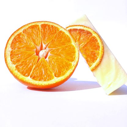 Close-up of Orange Serene artisan soap bar showing smooth texture and citrus detailing, enriched with real half orange