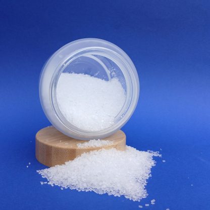 Bath salts in a frosted jar with bamboo lid on a blue background
