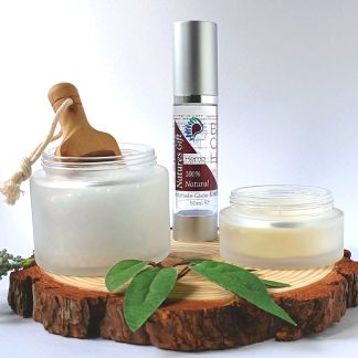 Bath Salts in a frosted Glass Jar bottle of BCH Naturals Lube and Candle on a slice of Wood with green leaves