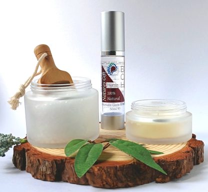 Bath Salts in a frosted Glass Jar bottle of BCH Naturals Lube and Candle on a slice of Wood with green leaves