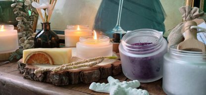 Sideboard view of Salts in a jar, a candle white star fish in front of a painting