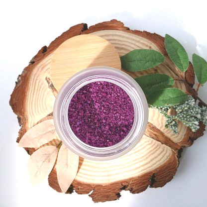 Orange Jasmine & Patchouli Sea Salts in a jar on a slice of wood with leaves