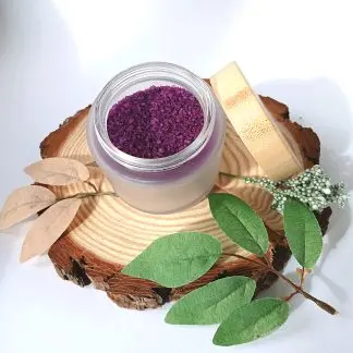 Purple Bath Salts in a jar, with Body Glide Oil and a candle on a slice of wood