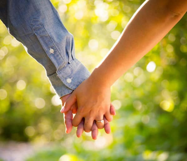 two people holding hand s outside in nature