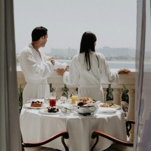 Couple in white robes enjoying a calm morning together — the art of slowing down and natural intimacy — BCH Naturals