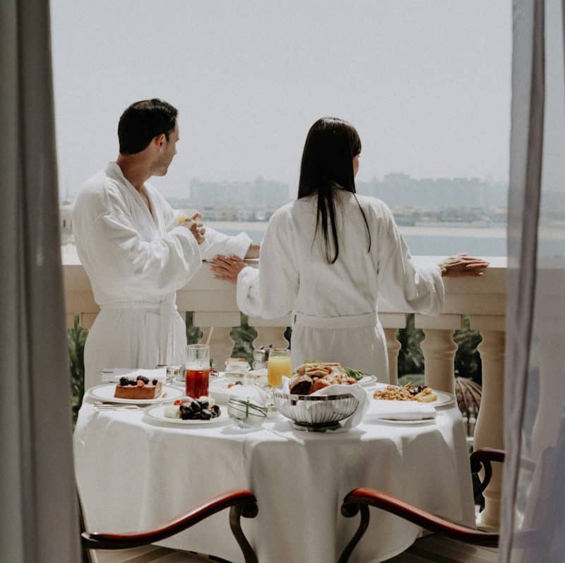 Couple in white robes enjoying a calm morning together — the art of slowing down and natural intimacy — BCH Naturals