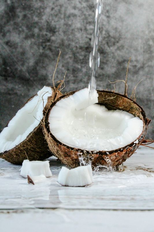 Coconut halves with coconut oil pouring in them