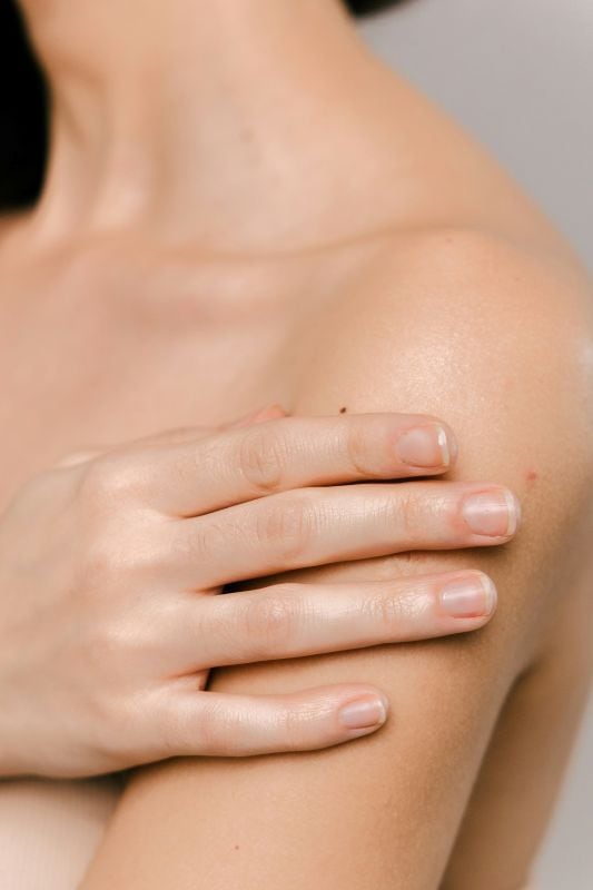 lady touching her shoulder bare skin