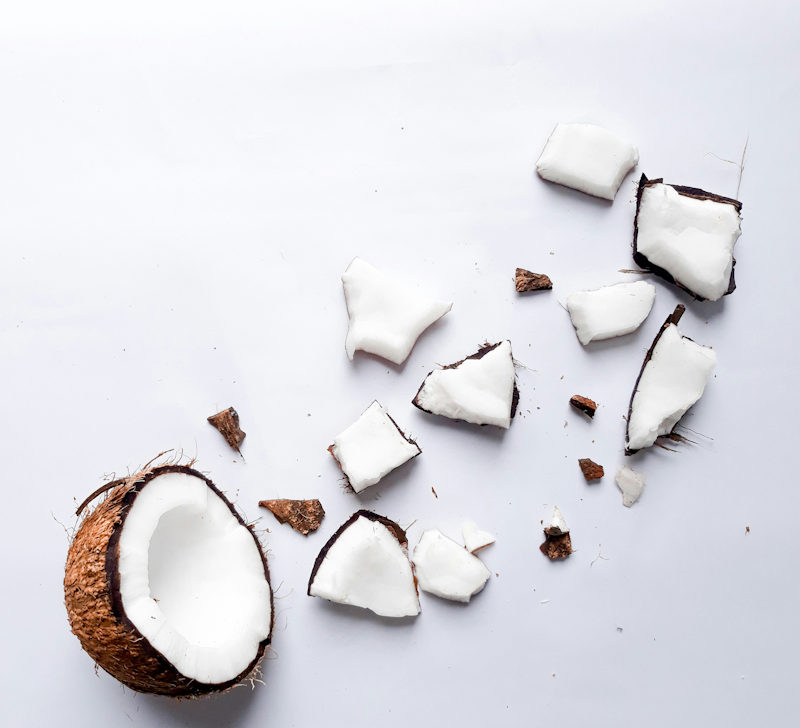 Fresh cracked coconut on white background — is coconut oil safe as a natural lubricant — BCH Naturals guide