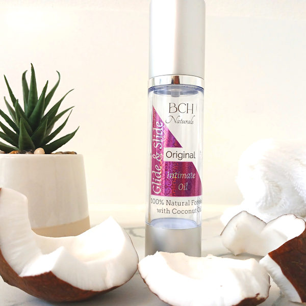 BCH Naturals Glide & Slide 100% natural coconut intimate oil displayed on white marble – with real coconut - a gentle, plant-based oil for connection and comfort